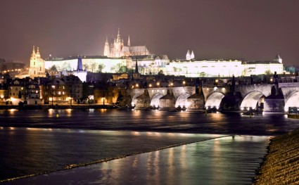 A view of Prague Castle and the Charles Bridge over the Vltava River in winter.