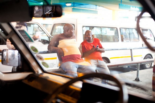 Two drivers take some time out while waiting for passengers.